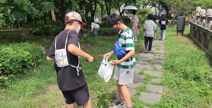 지난해 합정동 골목여행에 참가한 학생들이 탐방 중에 쓰레기를 줍고 있다.